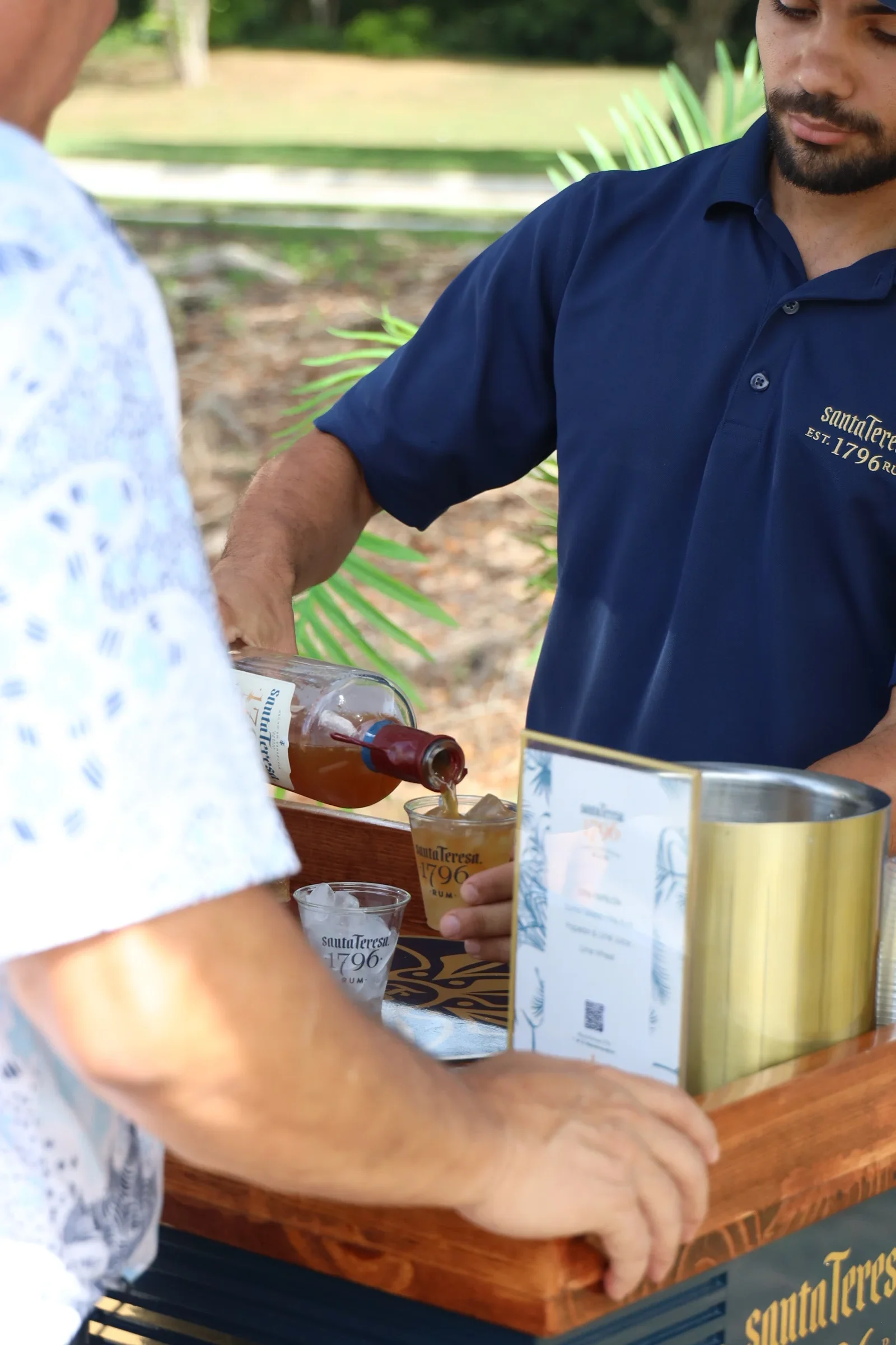 Un miembro del equipo de catering sirve una bebida en la mesa de servicio.