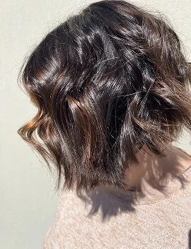 Dark brunette textured wavy bob haircut styled at Jura Draco Gold Coast salon