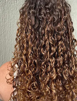 Defined healthy curls with golden highlights after professional hair treatment by Jura Draco Gold Coast