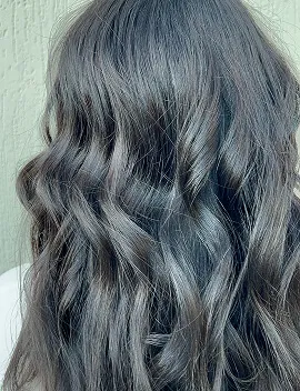 Glossy dark hair with soft waves showing healthy shine after hair treatment at Jura Draco Gold Coast salon