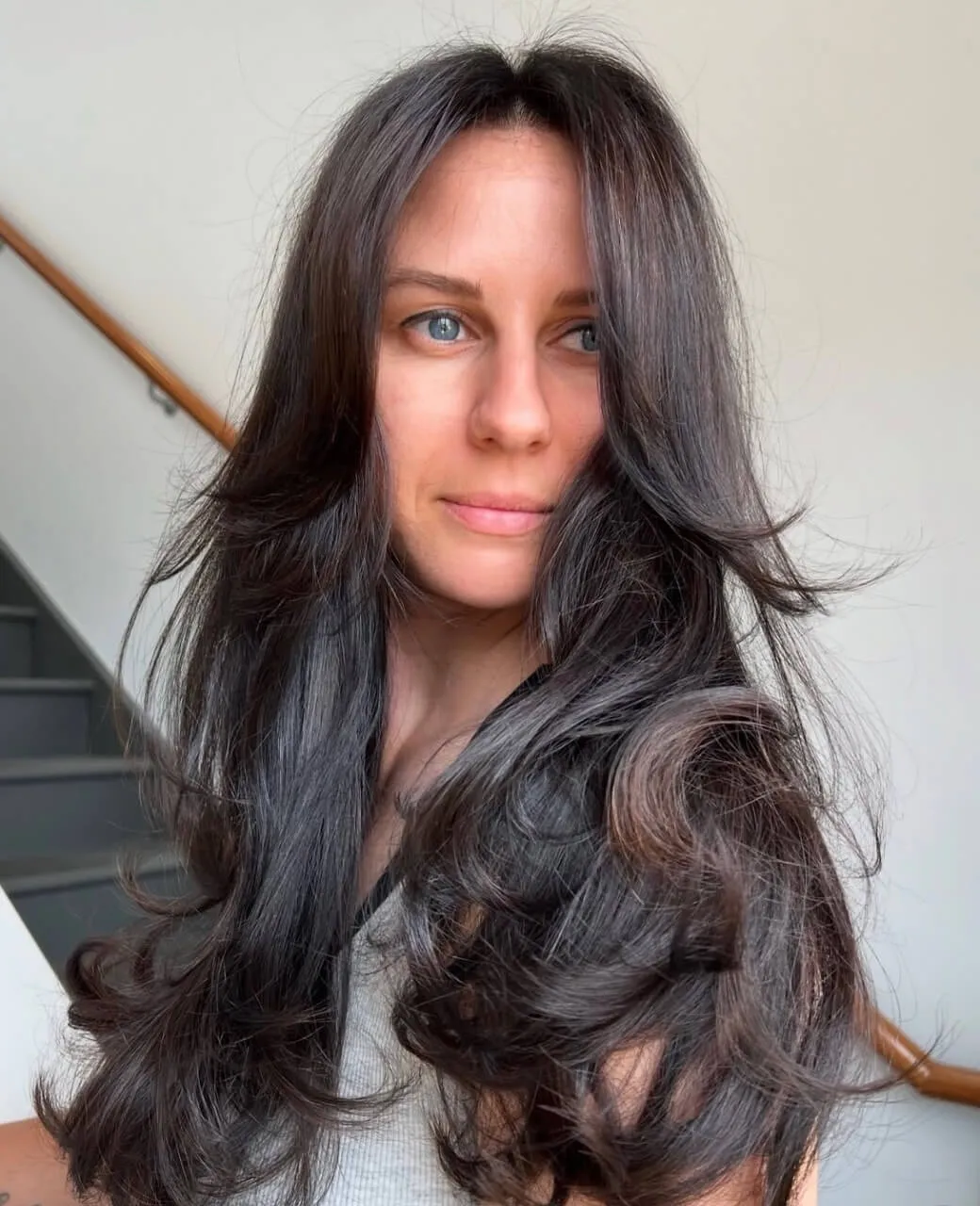 Client with long dark brunette tint colour and voluminous blow-dry waves at Jura Draco Gold Coast hair salon