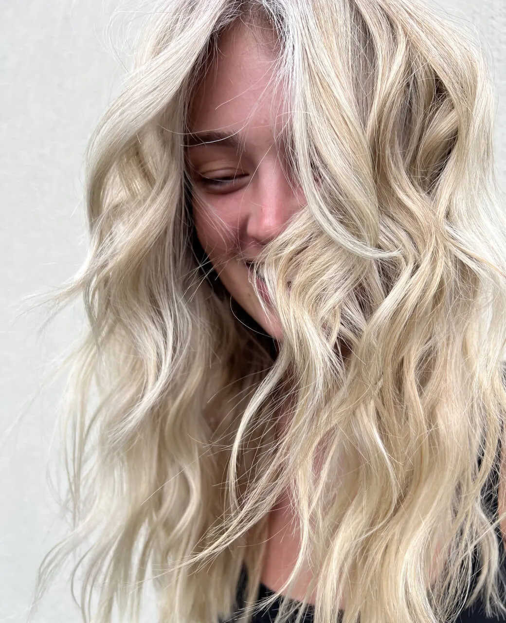 Platinum blonde beach waves on long hair achieved with full head foils at Jura Draco Gold Coast blonde specialists