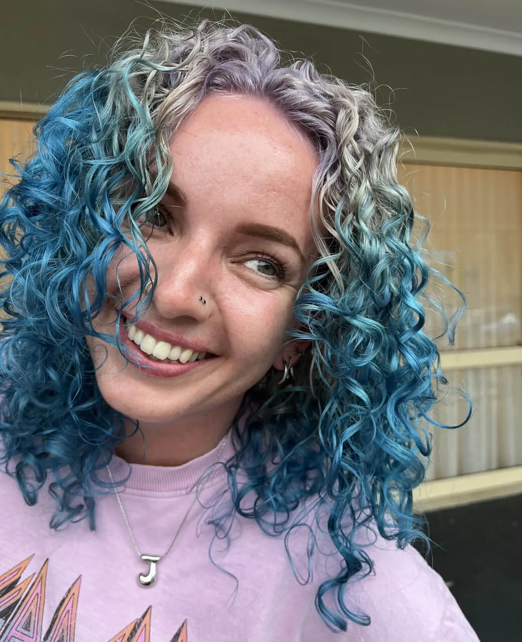 Vibrant teal blue and silver creative colour on curly hair by Jura Draco Gold Coast creative colour specialists