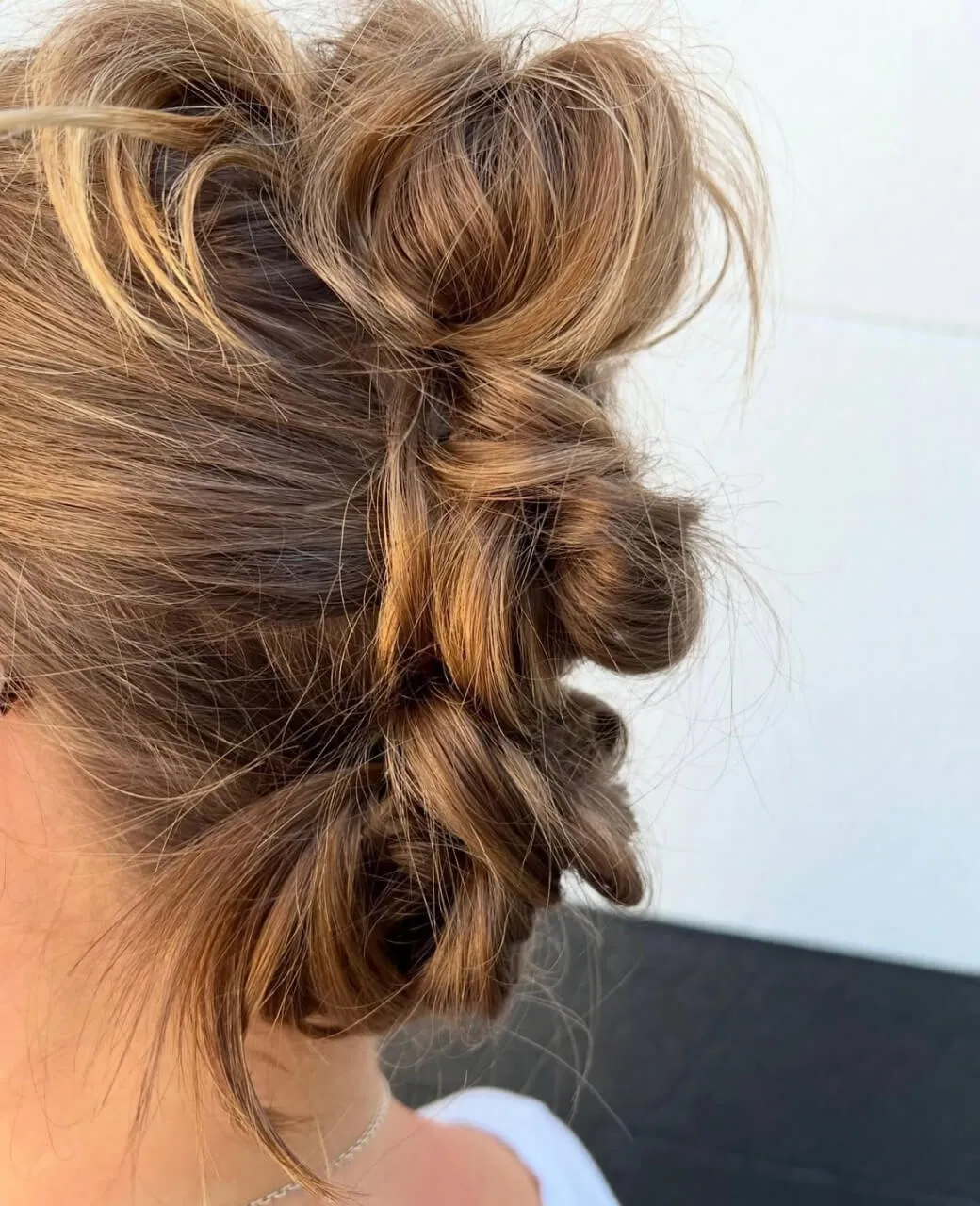 Textured twisted upstyle with soft loose pieces for event styling at Jura Draco Gold Coast hair salon