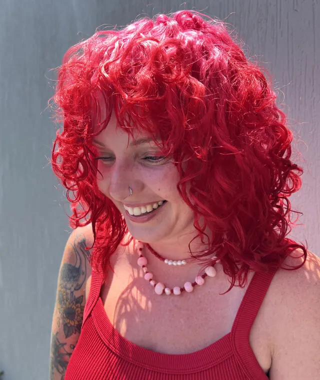 Vivid hot pink creative hair colour on curly textured hair by Jura Draco Gold Coast colour specialists
