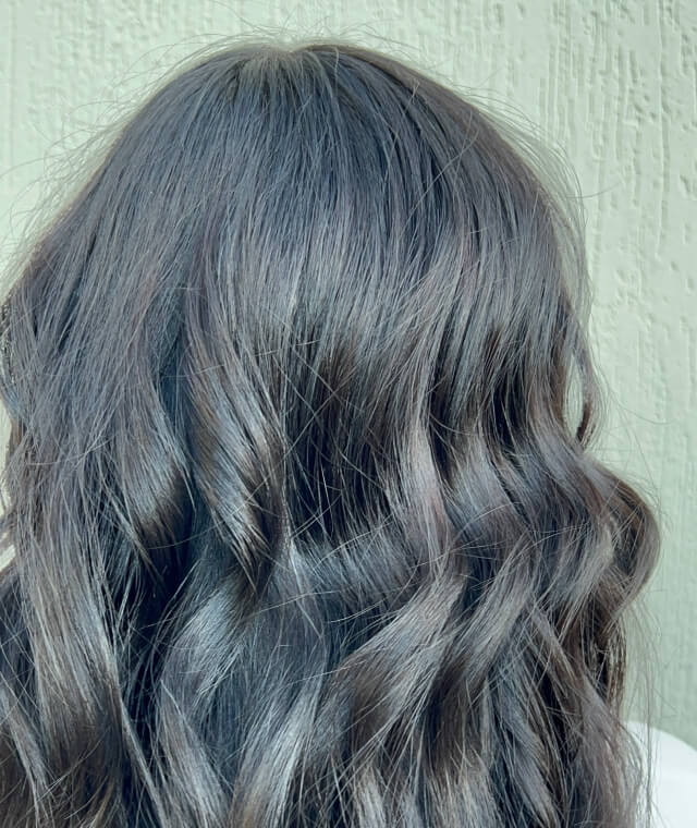 Smooth dark hair with glossy ash tones and soft waves after salon hair treatment at Jura Draco Gold Coast