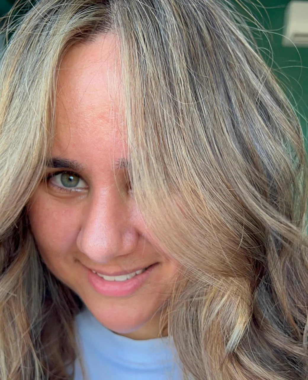 Smiling woman with sun-kissed blonde highlights and soft waves at Jura Draco Gold Coast