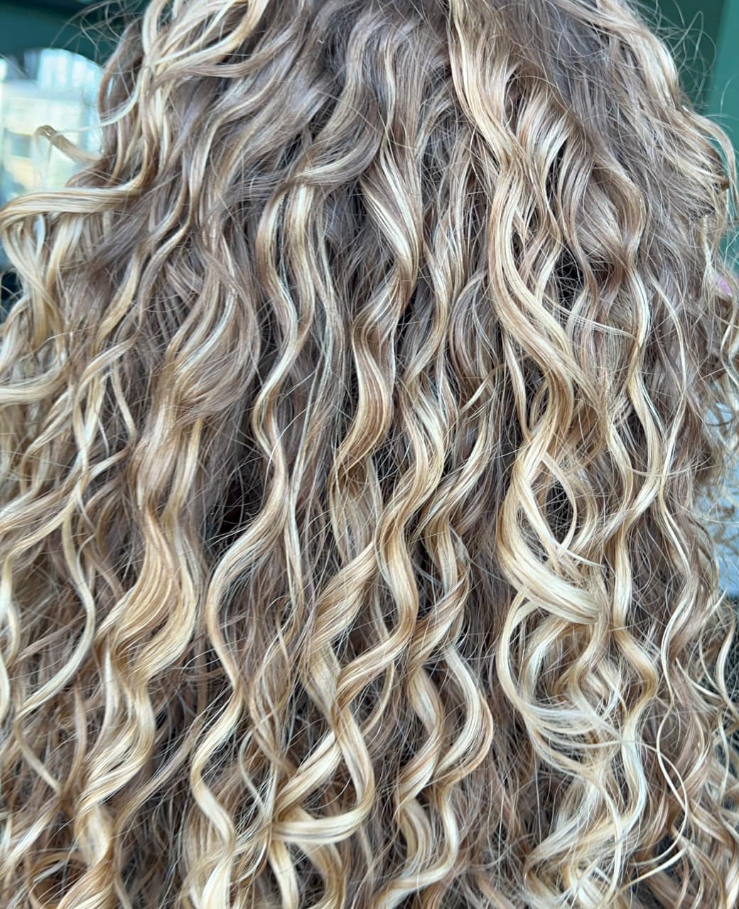 Blonde highlighted curls with natural dimension by Jura Draco Gold Coast blonde specialists
