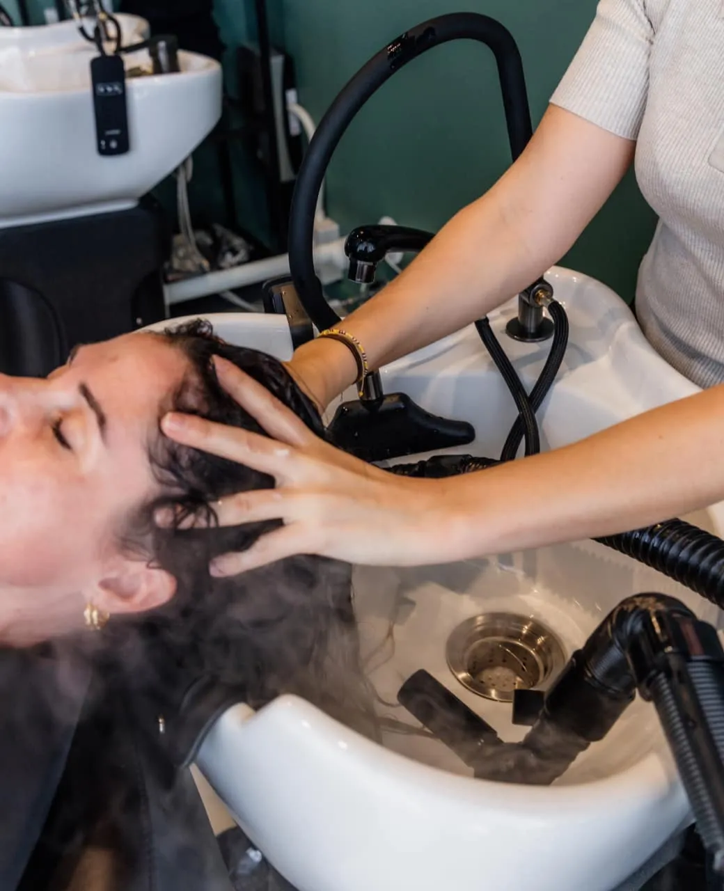 Water rinsing through hair at the wash basin during a hair treatment at Jura Draco Gold Coast