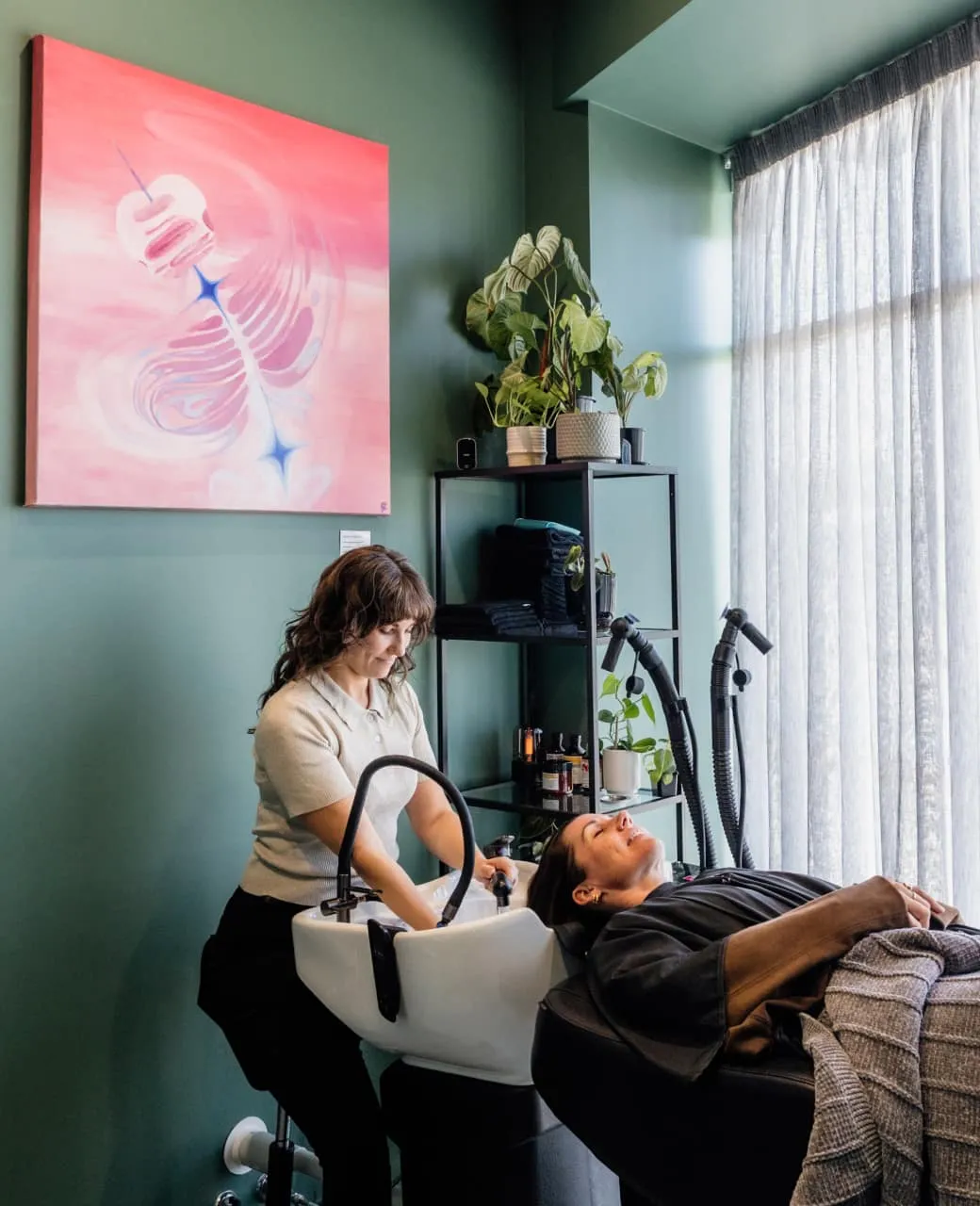 Client relaxing during a head spa hair treatment at the wash basin at Jura Draco Gold Coast salon