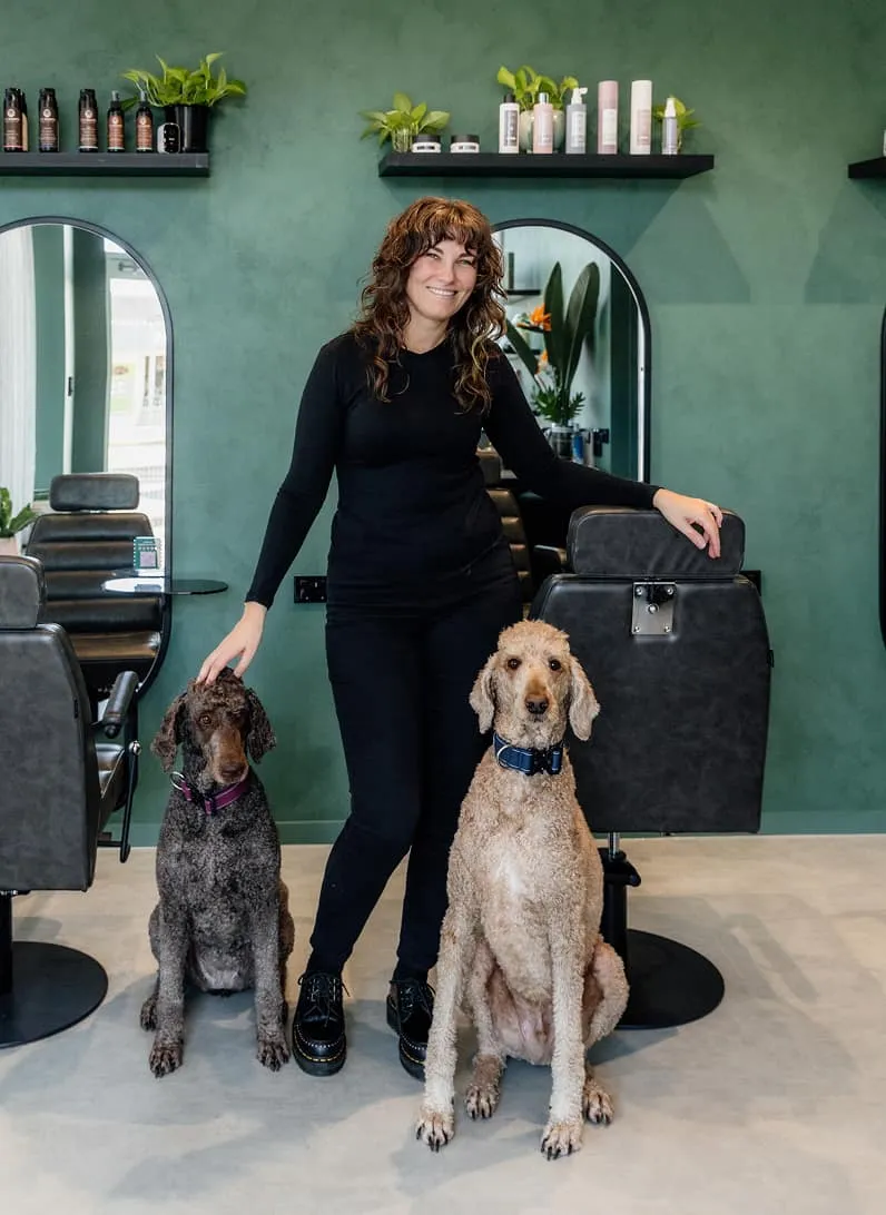 Inesa, founder of Jura Draco, with two standard poodles in the Gold Coast hair studio