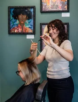 Hairstylist cutting a blonde bob for a client at Jura Draco salon in Labrador, Gold Coast