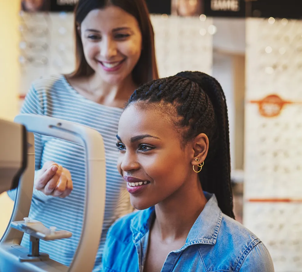 Young woman undergoing an eye examination with an optometrist supervising.