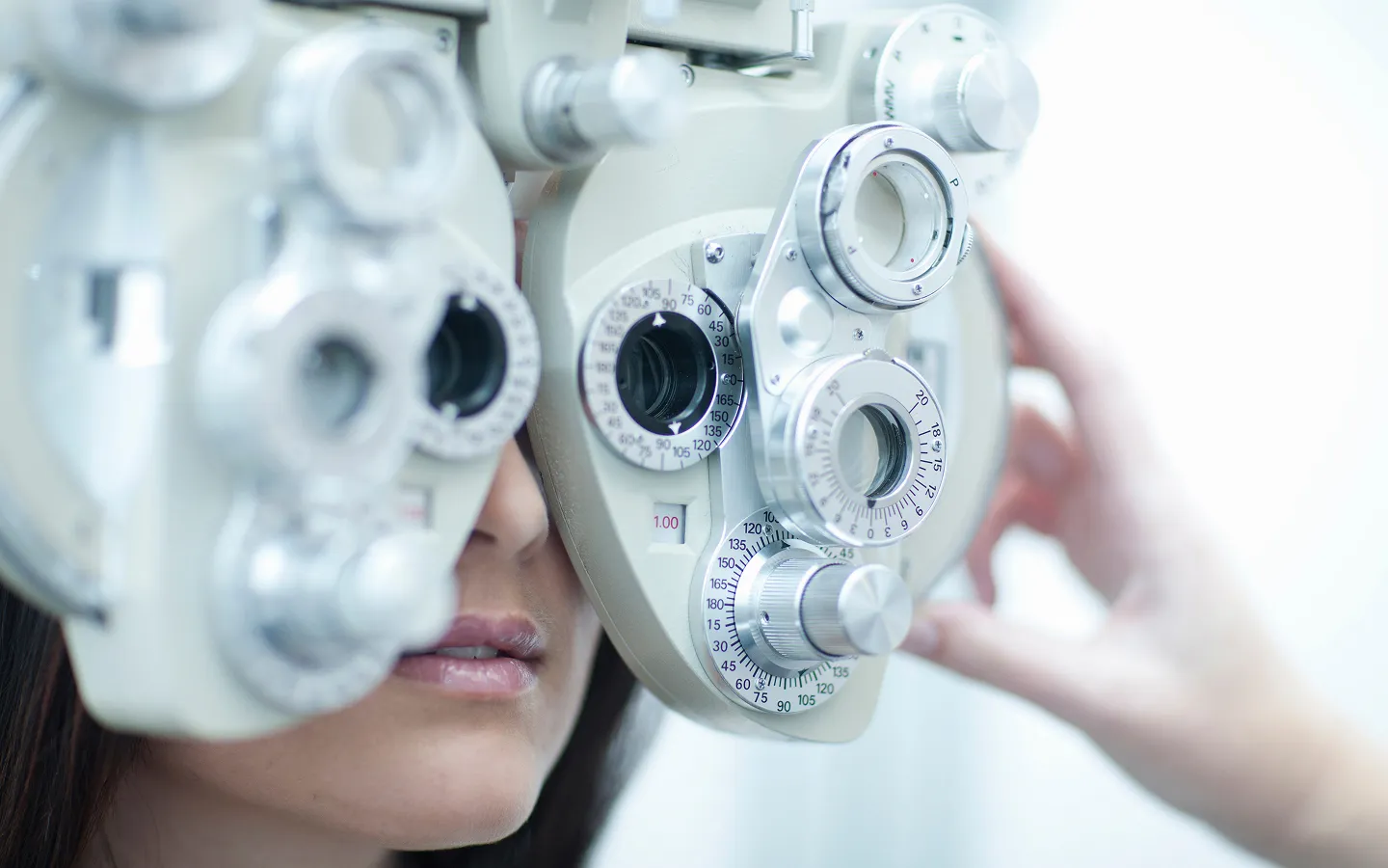 Close-up of a patient undergoing an eye test with a phoropter instrument.