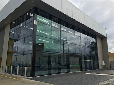 Modern car dealership building with large glass windows and signs for Mercedes-Benz and Marshalls.