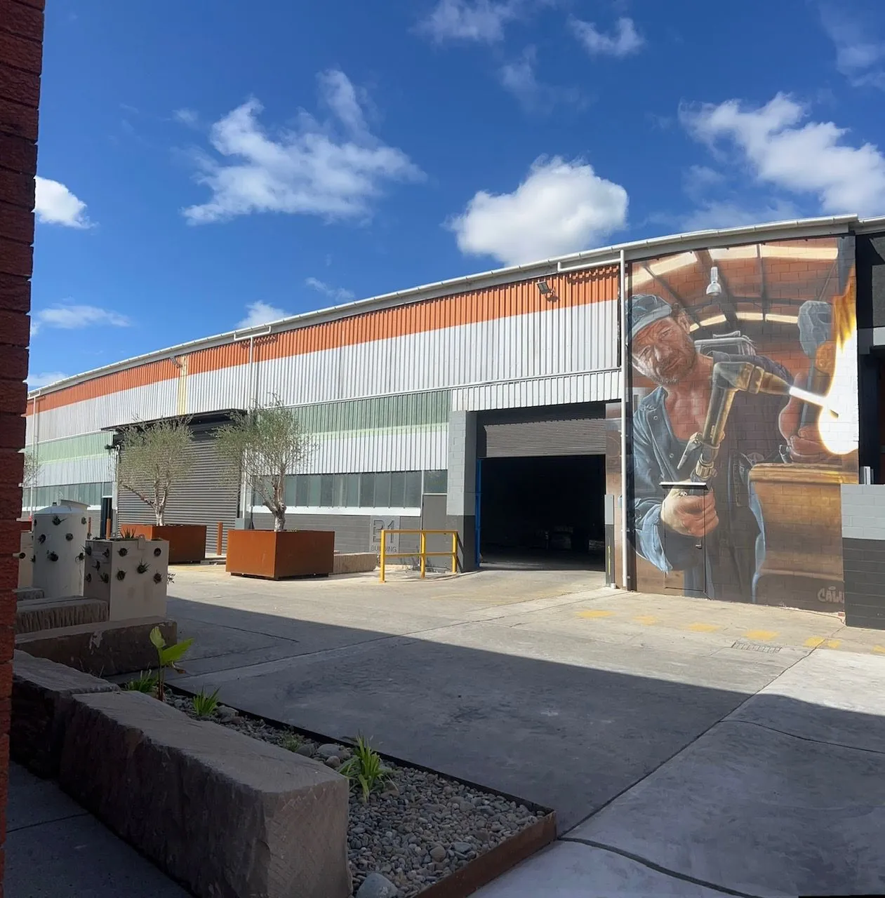 Modern car dealership building with large glass windows and signs for Mercedes-Benz and Marshalls.