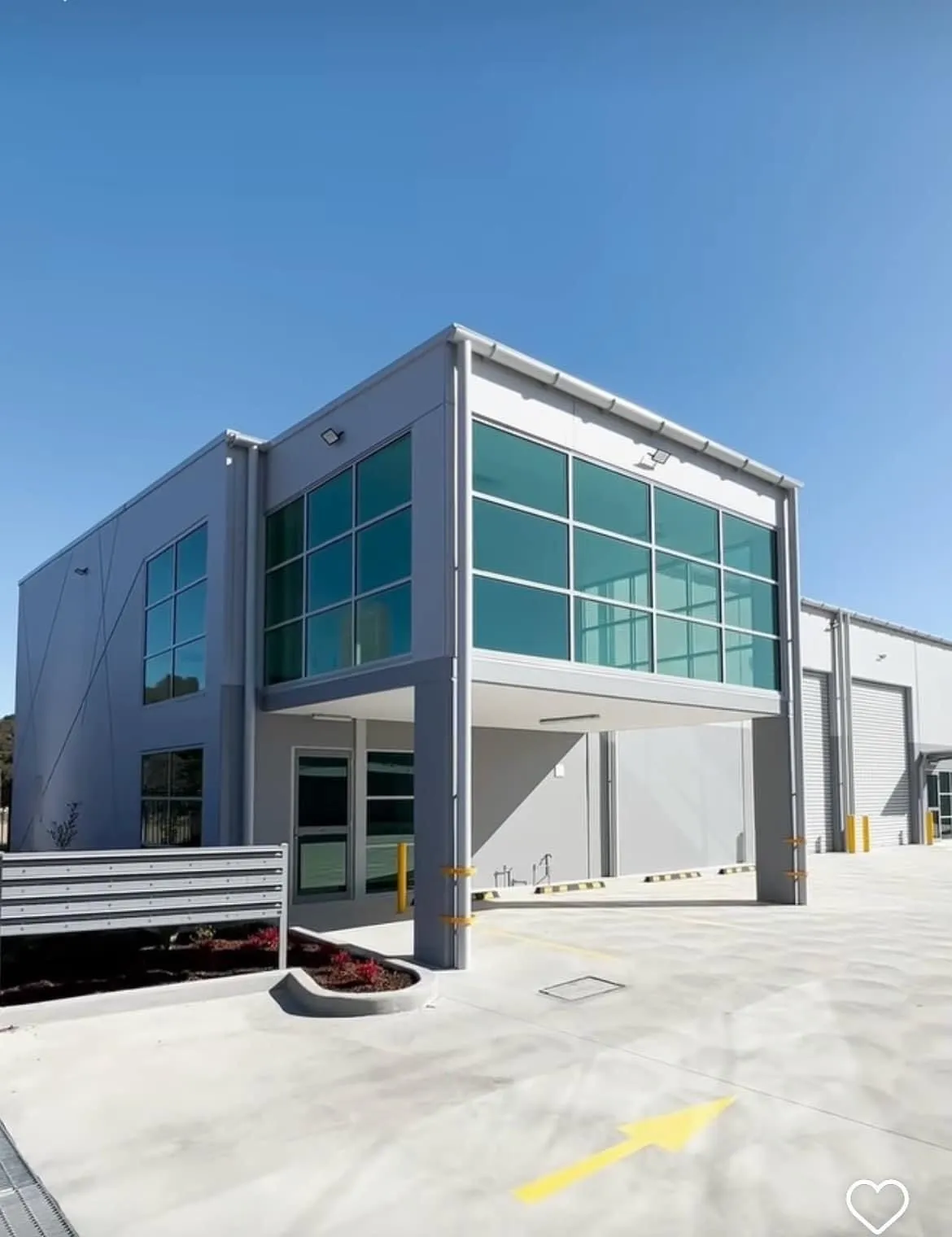 Modern car dealership building with large glass windows and signs for Mercedes-Benz and Marshalls.