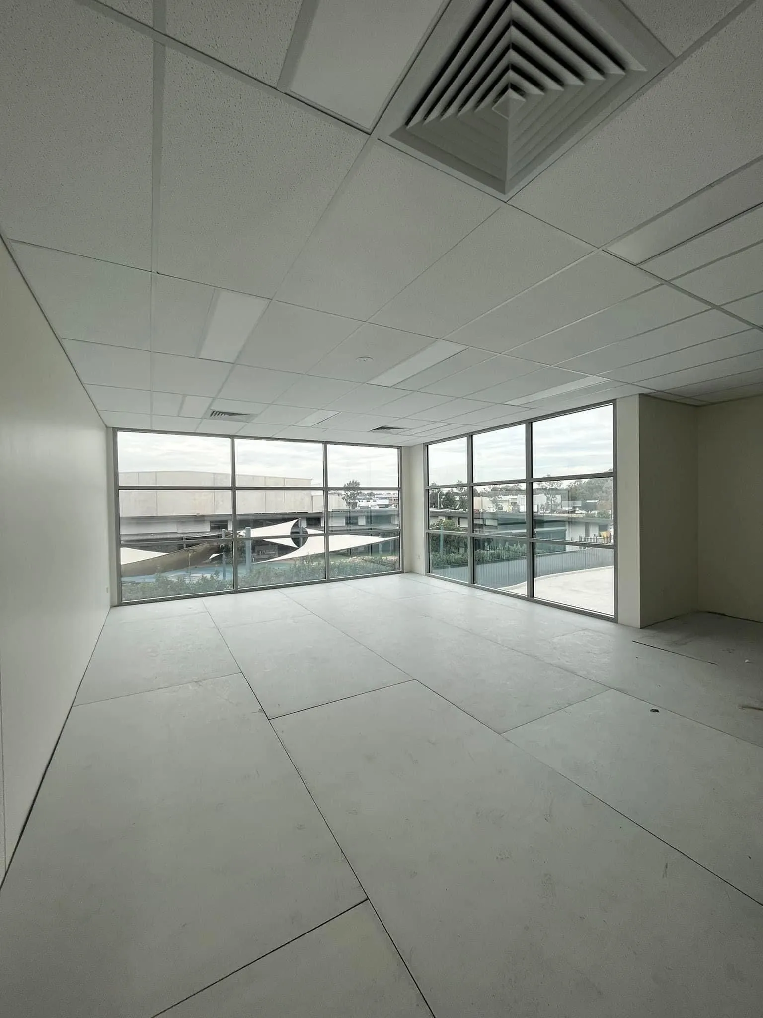 Modern car dealership building with large glass windows and signs for Mercedes-Benz and Marshalls.