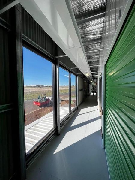 Modern car dealership building with large glass windows and signs for Mercedes-Benz and Marshalls.