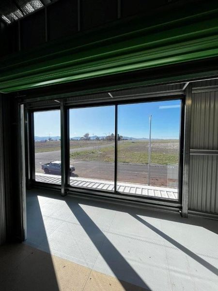 Modern car dealership building with large glass windows and signs for Mercedes-Benz and Marshalls.