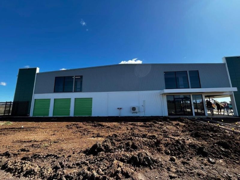 Modern car dealership building with large glass windows and signs for Mercedes-Benz and Marshalls.