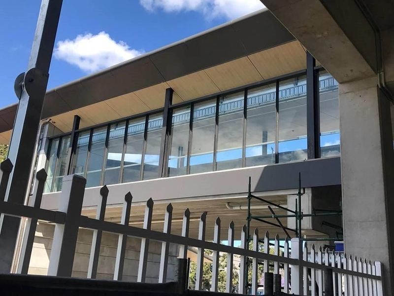 Modern car dealership building with large glass windows and signs for Mercedes-Benz and Marshalls.