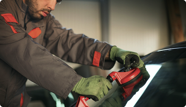 Image showing a worker replacing a front window on a car (auto glass replacement)