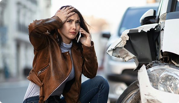 Image of an anxious woman on the phone with her insurance because she was in an accident.
