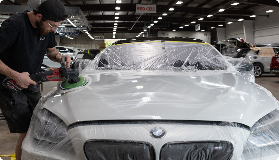 K-ceps worker buffing out the hood of a BMW after a Paint Dent Removal correction job.