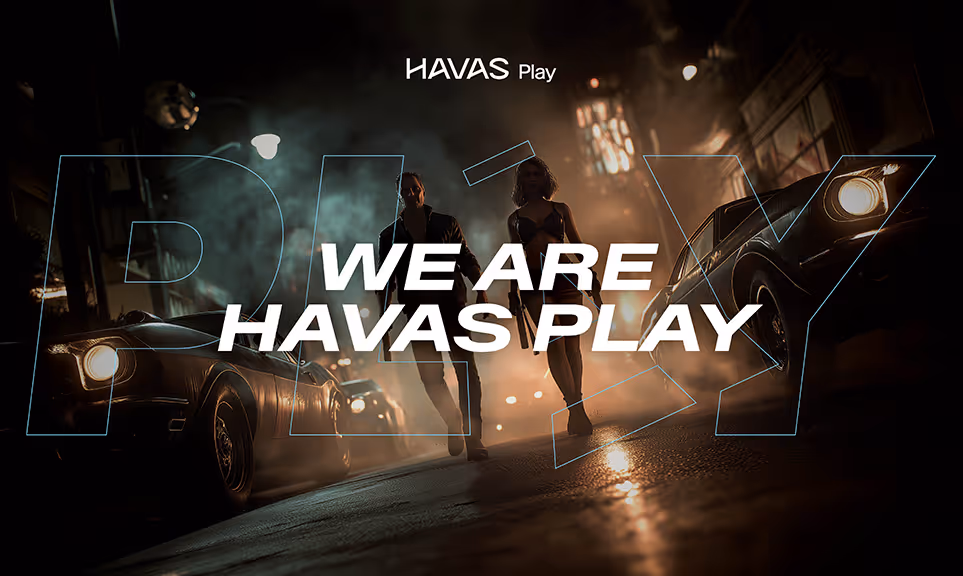 Two people walking on a foggy street at night between vintage cars, overlaid with 'WE ARE HAVAS PLAY' text.