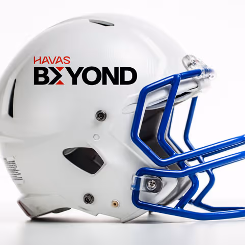 White football helmet with blue faceguard and HAVAS BEYOND logo on the side.