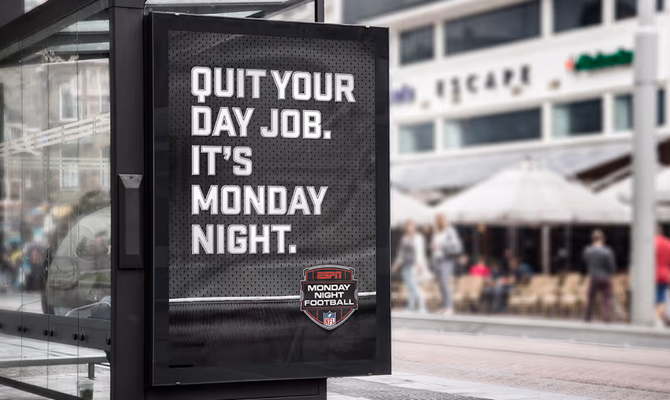 Bus stop advertisement with text 'Quit your day job. It's Monday night.' promoting ESPN Monday Night Football.