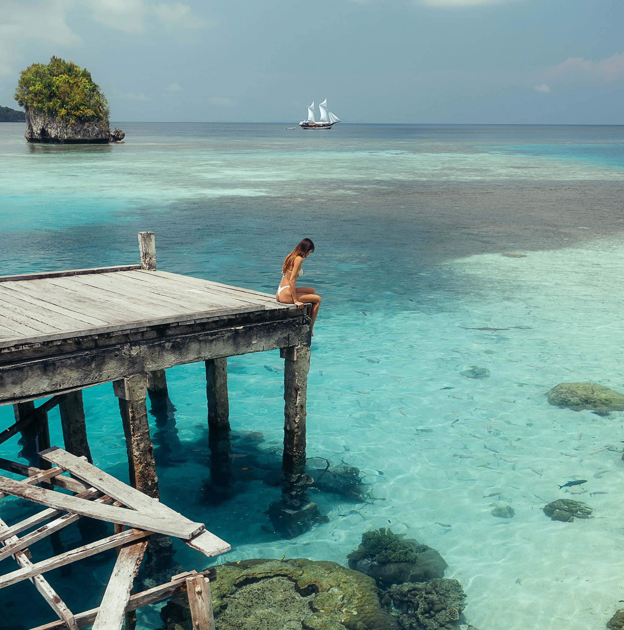 Guest wading in a lagoon with reef sharks