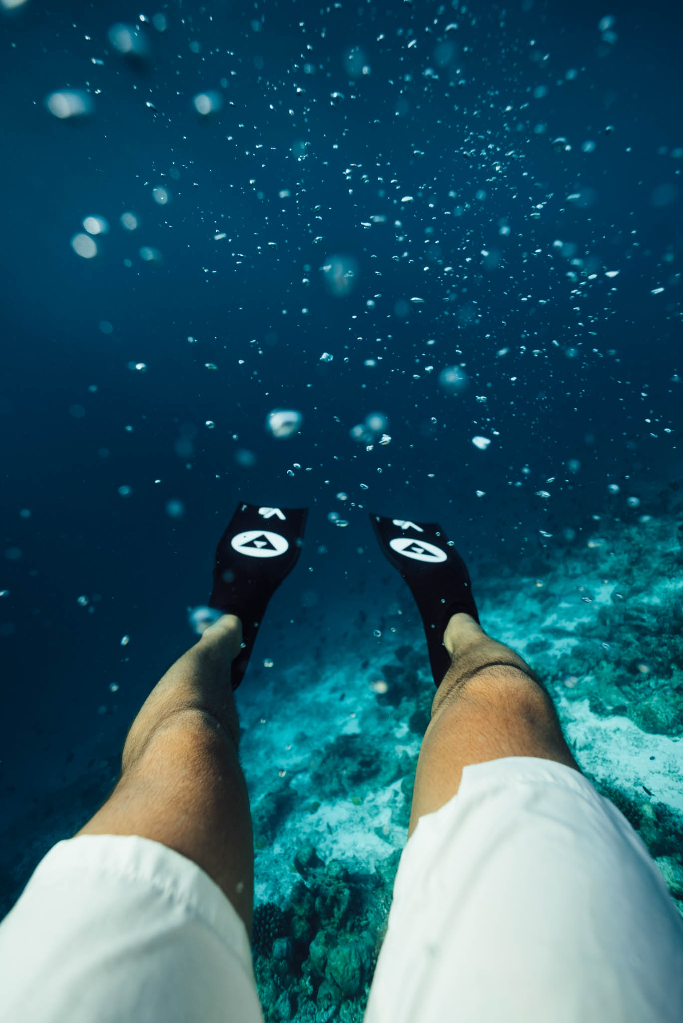 Snorkeler with fins over a coral reef