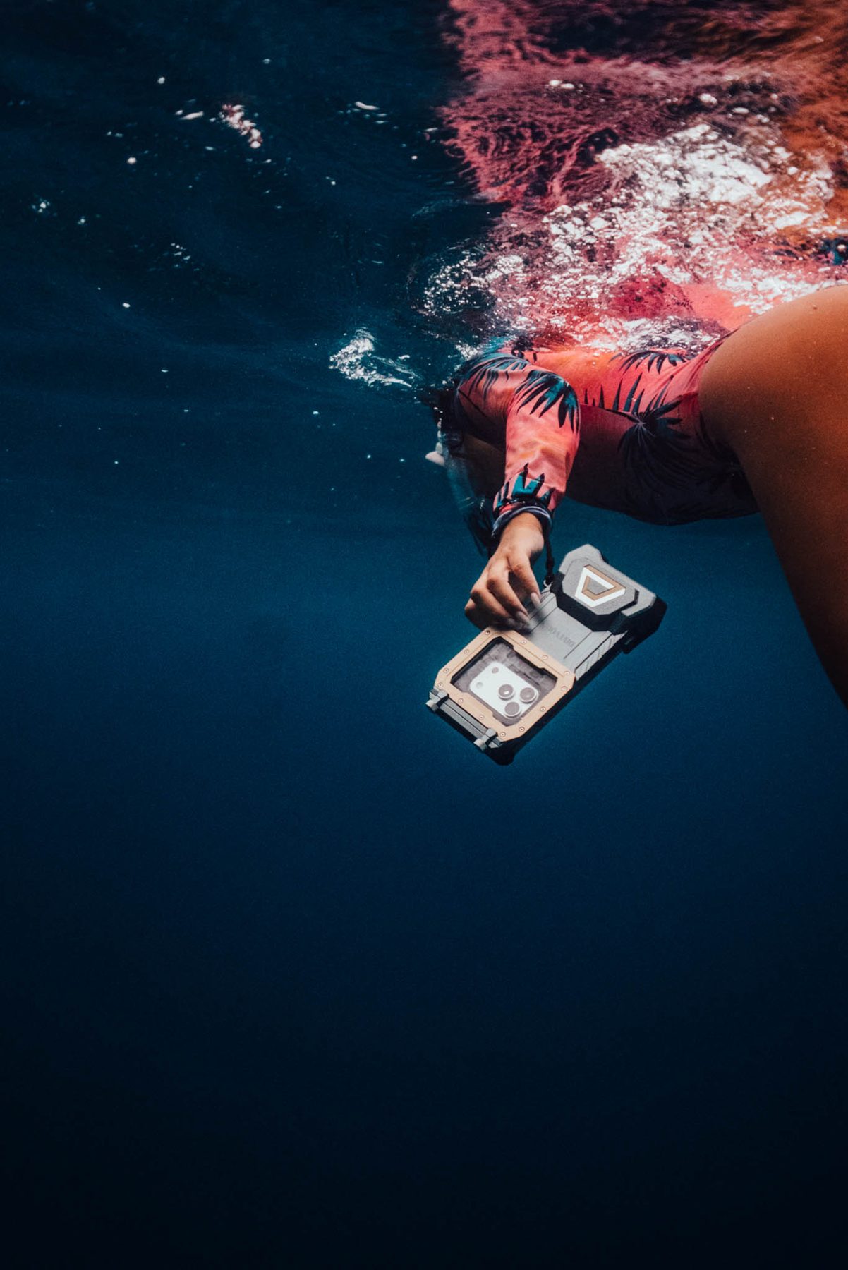 Swimmer in a rash guard filming with a DiveVolk housing