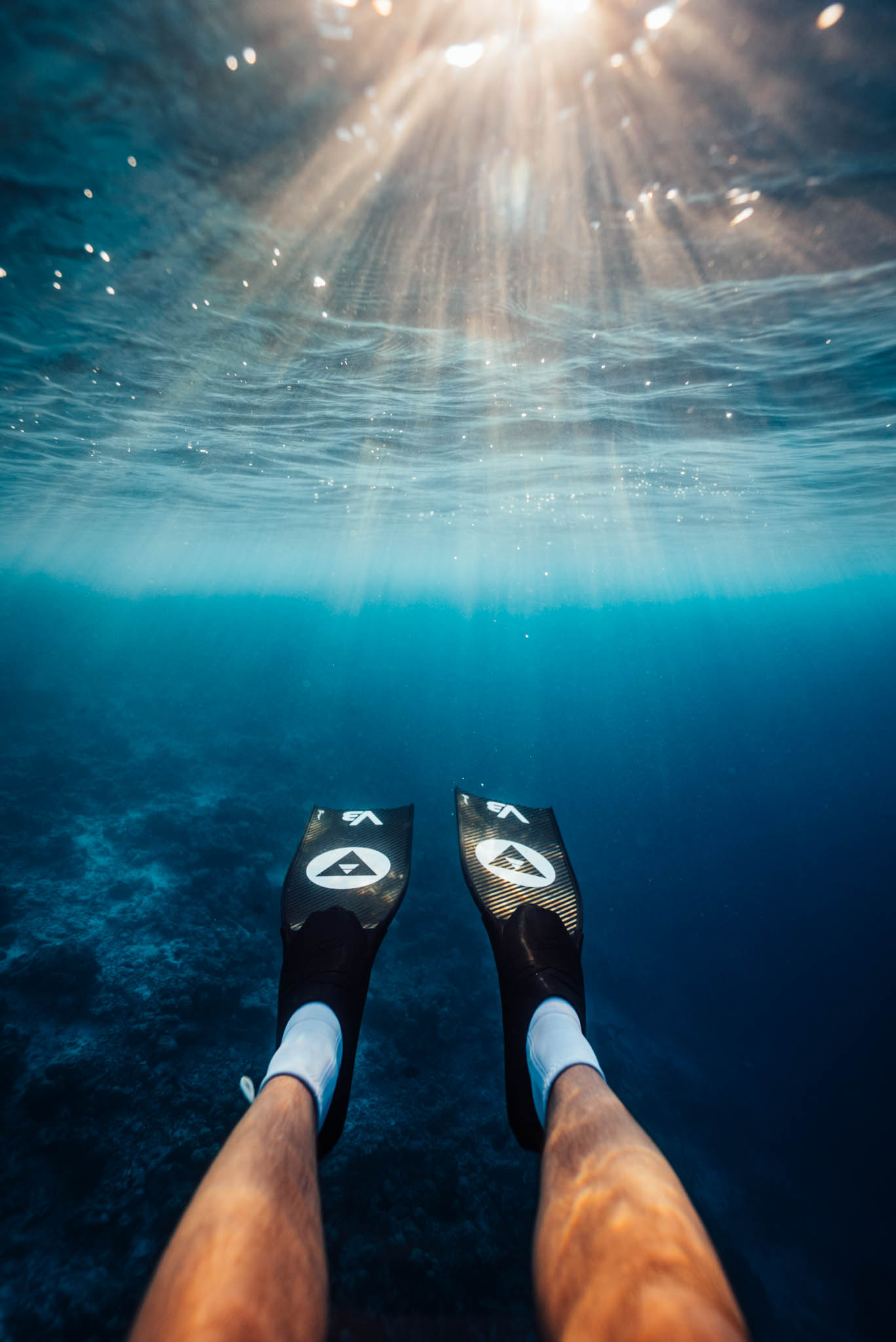 Sunburst through the surface above a pair of carbon fins