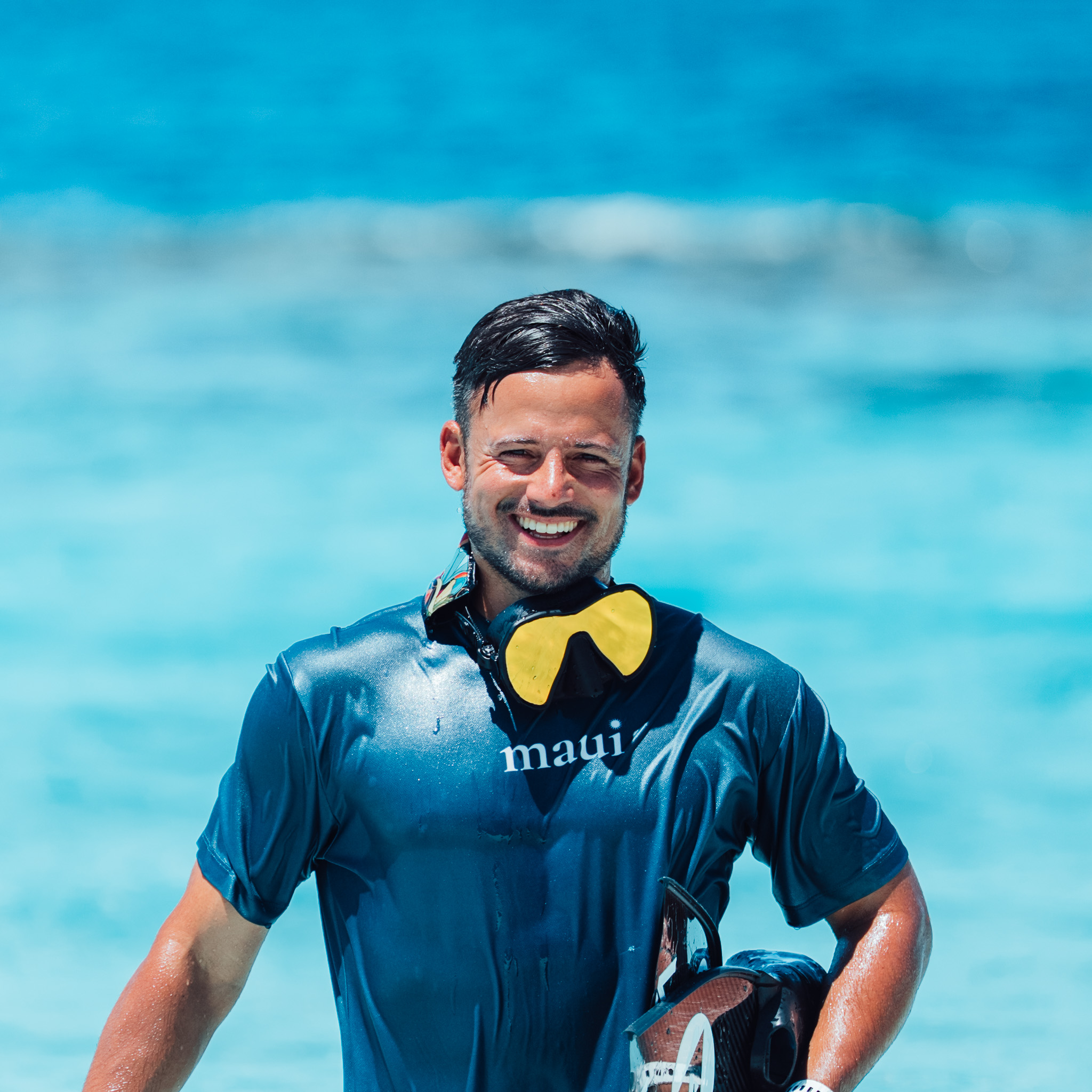 Smiling snorkeler with a Beuchat Maxlux S mirrored mask around his neck