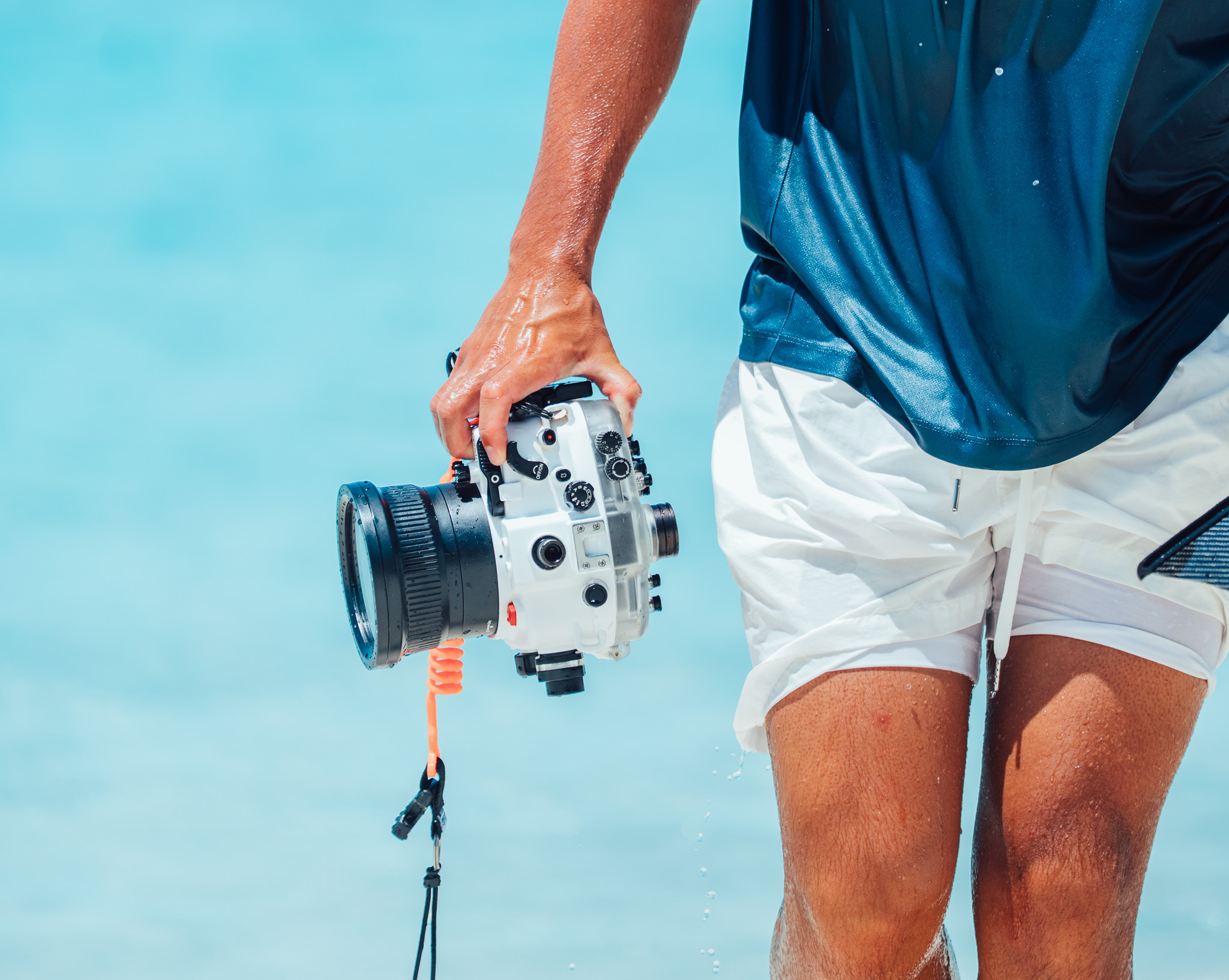 Snorkeler wading through the sea holding a SeaFrogs housing with a dome port