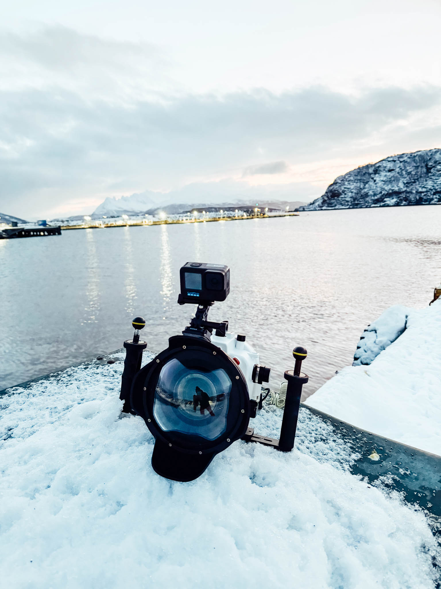 SeaFrogs housing with a dome port and a GoPro on top, resting in the snow by a Norwegian fjord