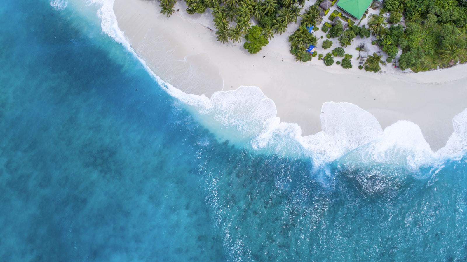 Aerial view of waves breaking on a Maldives island beach
