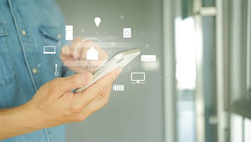 A person using a smartphone with digital icons representing automation in real estate business