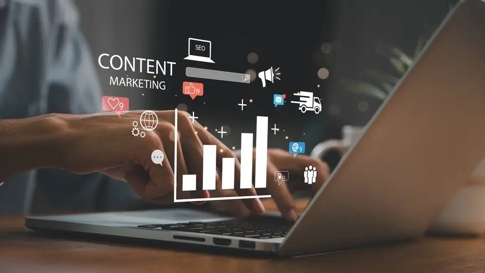 A person typing on a laptop with digital content marketing and SEO graphics.