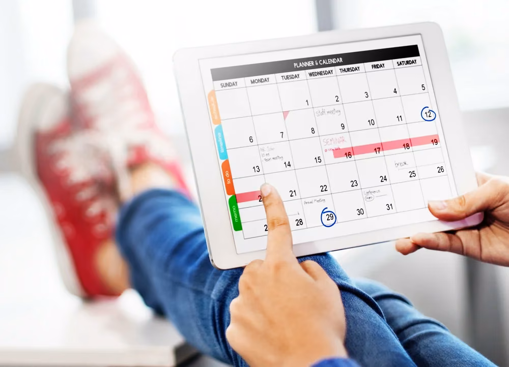 Person planning an AI-driven content calendar on a tablet for a small business marketing strategy