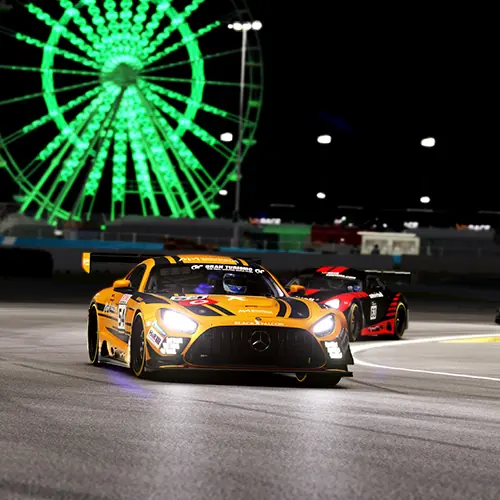 Yellow and black Mercedes race car with another black and red race car behind, racing on a track at night with a large illuminated green Ferris wheel in the background.