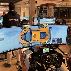 Racing simulator setup with a curved monitor displaying a top-down view of an orange race car and a racing wheel controller in front of it.