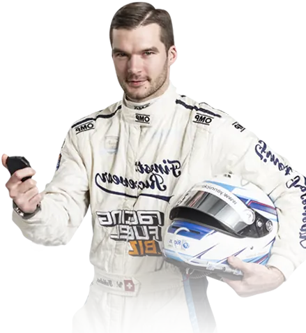 Race car driver in white racing suit holding a white and blue helmet and a black object in his right hand.