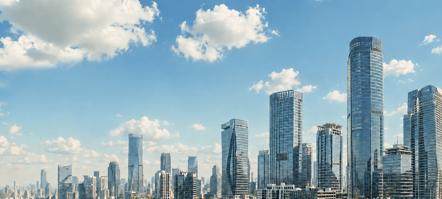 City skyline with tall modern glass skyscrapers under a blue sky with scattered clouds.