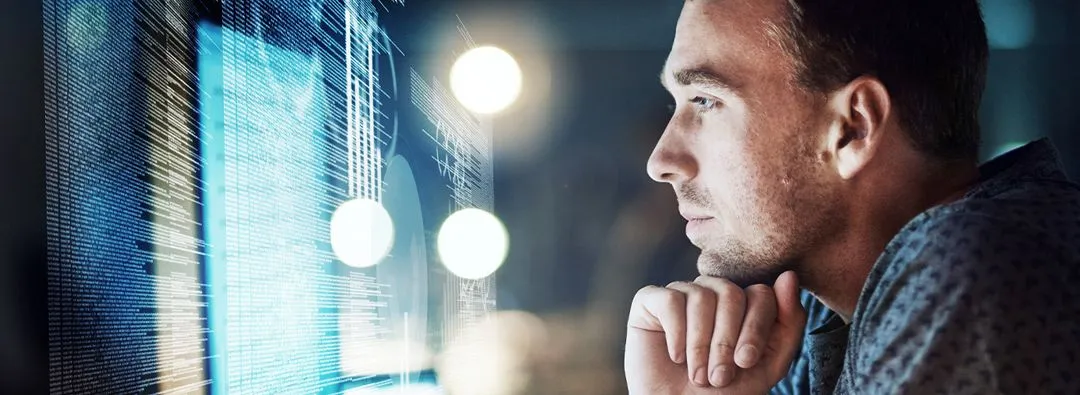 Ein Mensch, der interessiert auf ein Bildschirm schaut. 