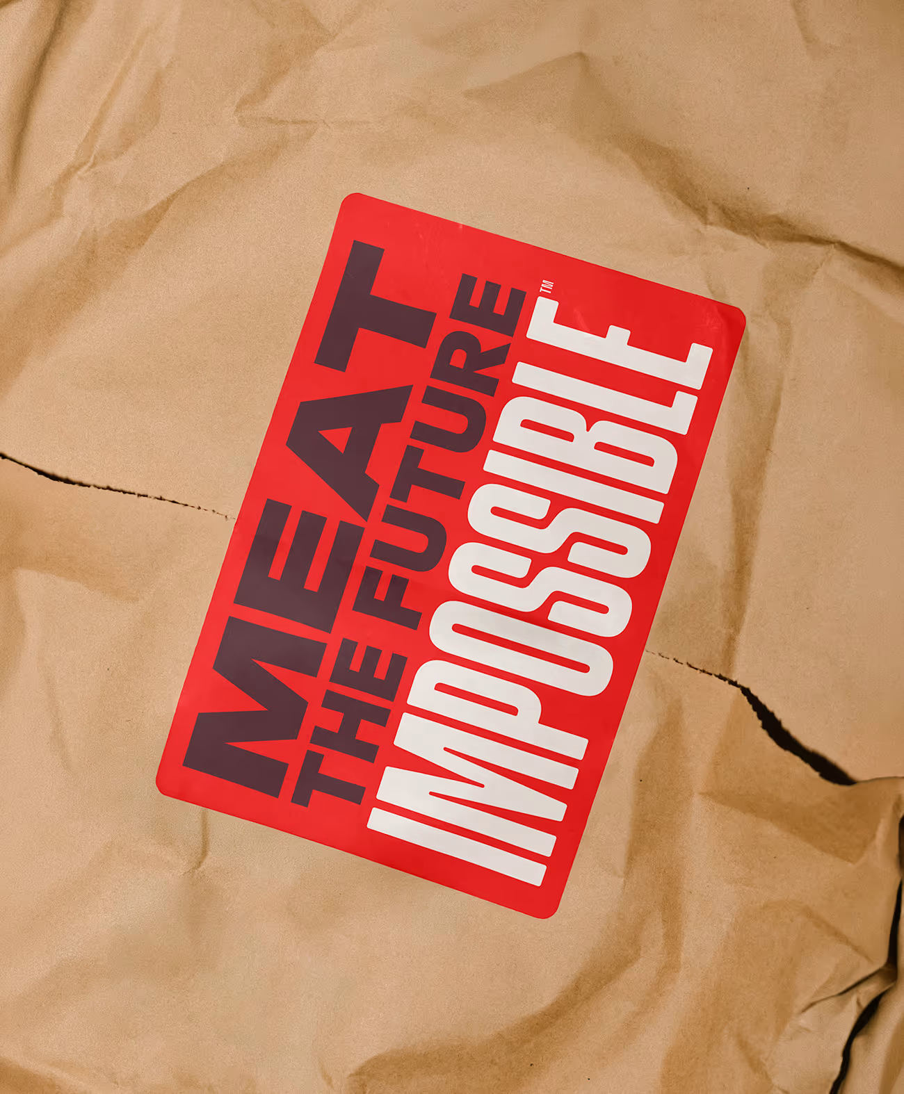 Brown paper bag with a red and black label reading 'MEAT THE FUTURE IMPOSSIBLE'.