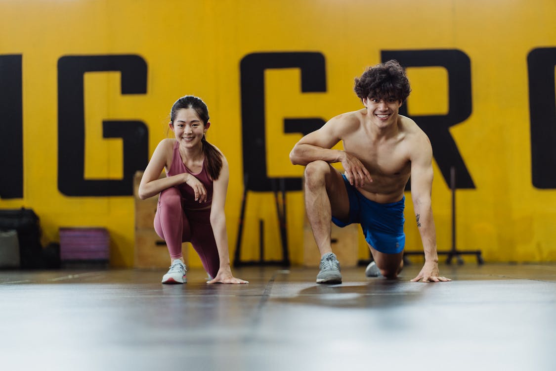 Free Man and Woman Exercising Together at the Gym Stock Photo